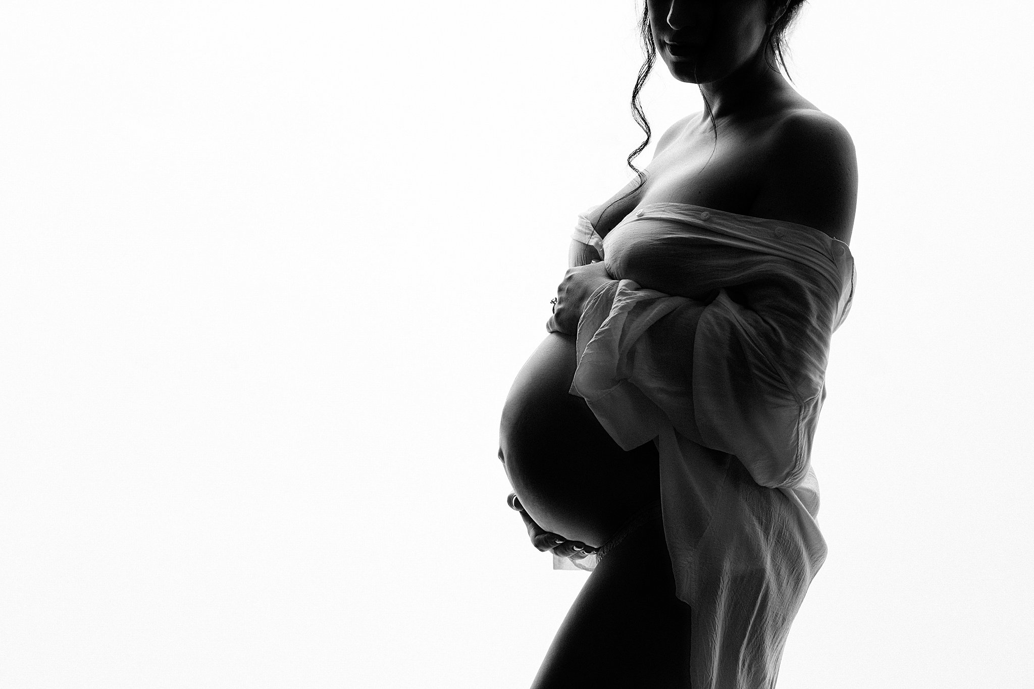 silhouette of a baby bump with a shirt draped over mom Baby Love Atlanta