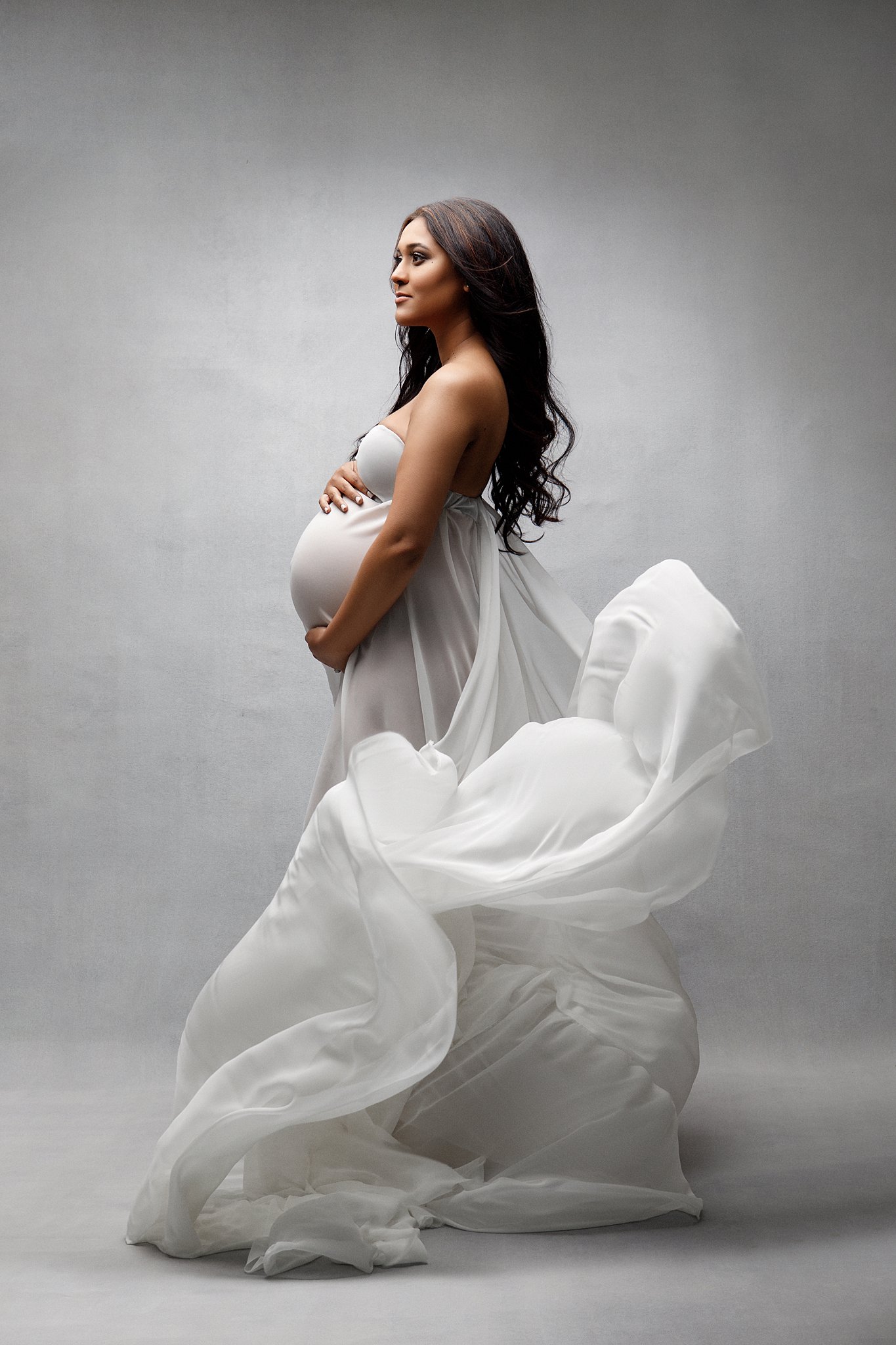 woman in a white maternity gown with the train flying Miami Birthing Centers