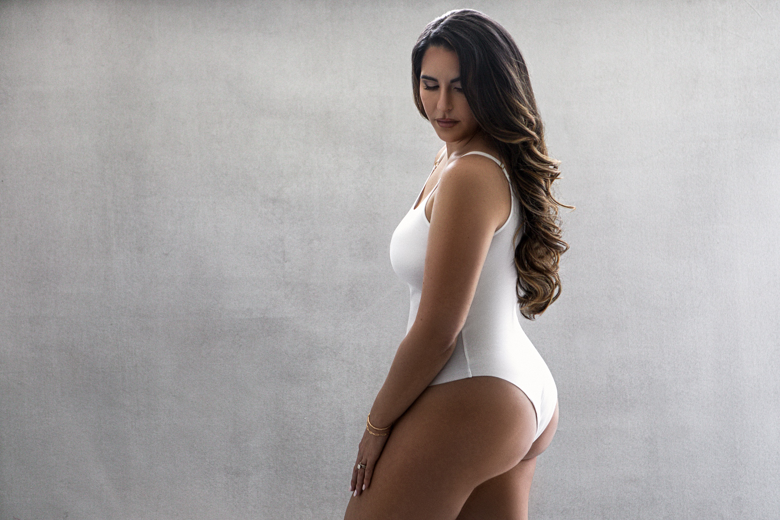 woman in white body suit with a tan from a miami tanning salon