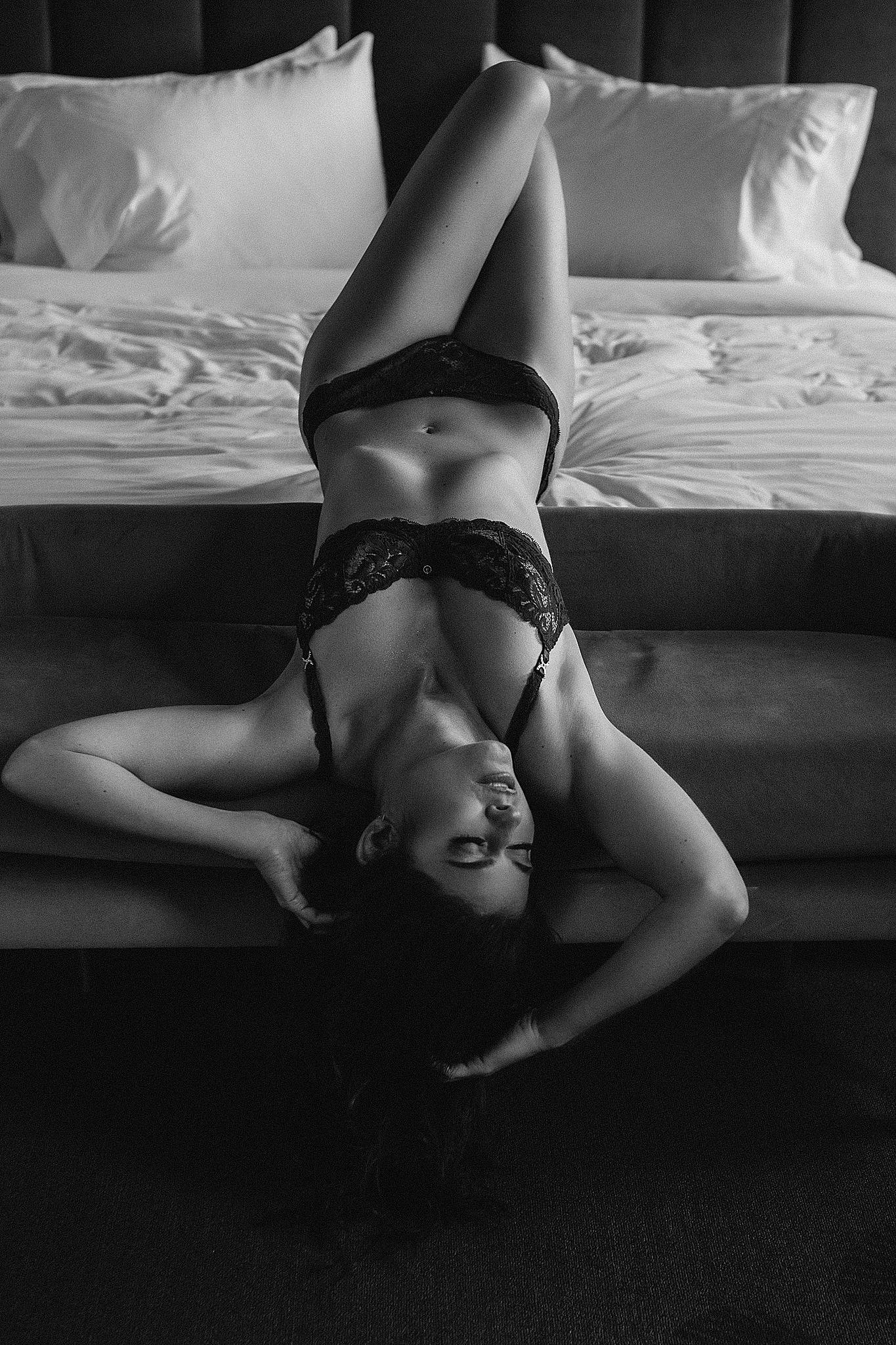 woman in lace lingerie laying upside down on a bed