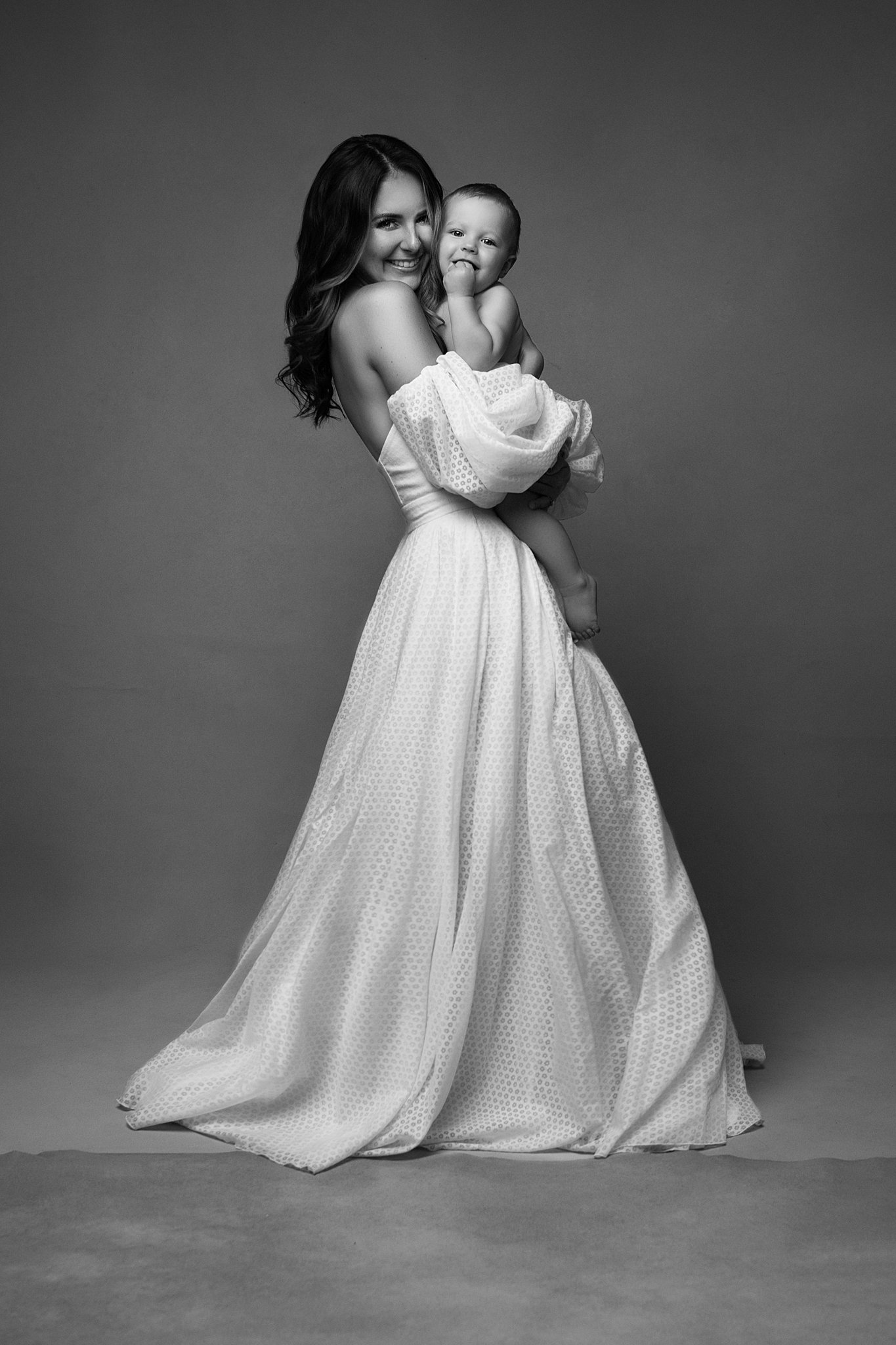 woman in long gown holding her newborn Atlanta pediatricians