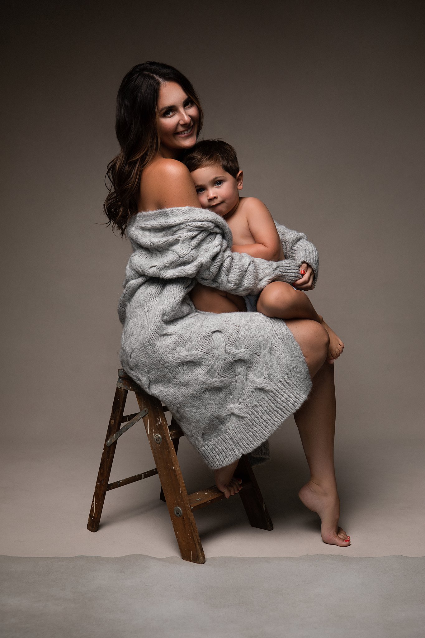 mom and son snuggling on a stool