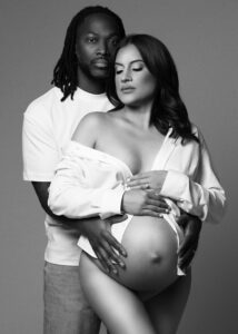 Studio maternity portrait with couple posing with serious expression