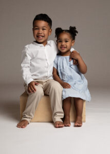 Two young children in coordinated white and blue outfits