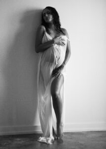 Maternity portrait in natural light by the wall