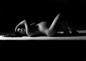 Black and white silhouette maternity portrait with dramatic lighting