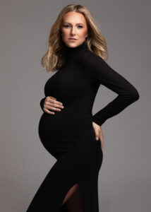 Elegant maternity portrait in black gown, side pose in Fort Lauderdale luxury studio