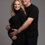Classic maternity portrait of couple in studio, soft lighting and natural pose