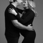 Intimate studio maternity portrait with expecting couple smiling and close