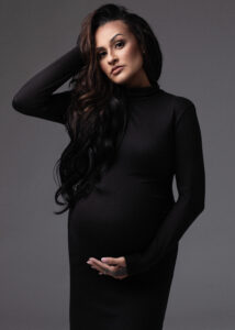 Studio image of mother-to-be in fitted black dress